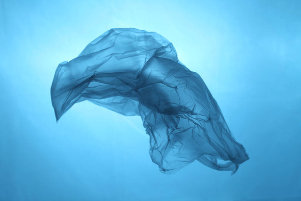 Plastic bag in blue water, garbage under water, plastic pollution of the oceans. - Foto, Imagem
