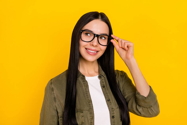 Photo of sweet millennial lady look promo wear spectacles khaki outfit isolated on yellow color background. - Foto, Bild