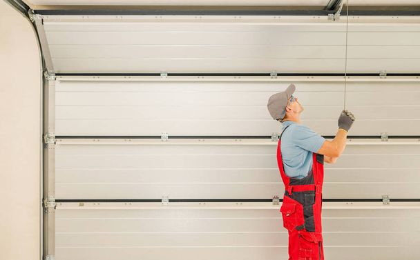 Automatic Residential Garage Doors Installation Performed by Professional Caucasian Technician in His 40s. - Foto, Bild
