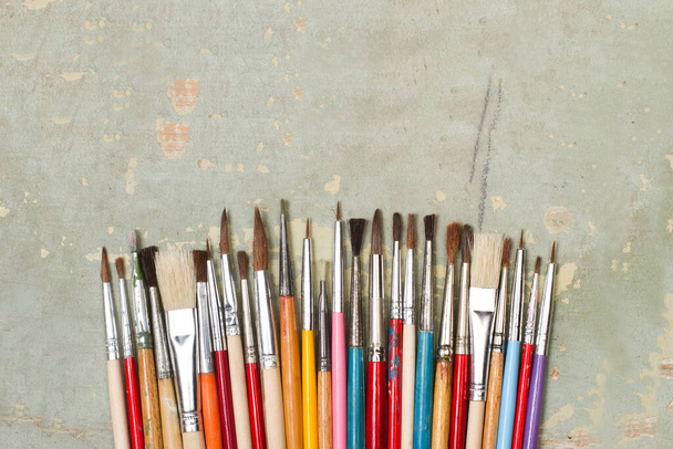 Colored artistic paintbrushes on a green wooden background with copy space - Photo, Image