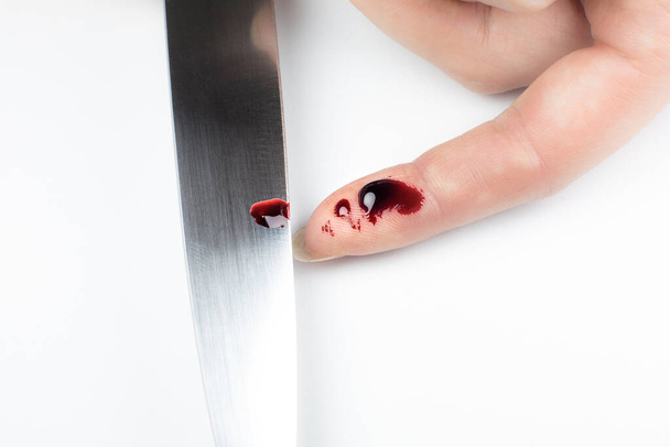 Woman cut her finger with a knife while cooking on the kitchen. Finger with blood, cooking accident. - Foto, imagen