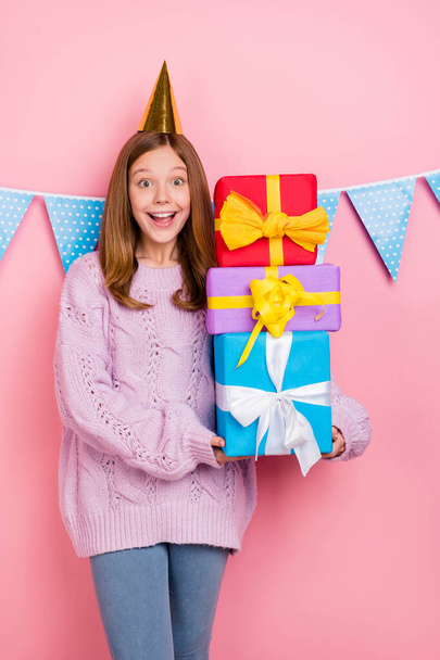 Vertical photo of shiny impressed girl dressed knitted pullover headwear holding gifts pile isolated pink color background. - Φωτογραφία, εικόνα
