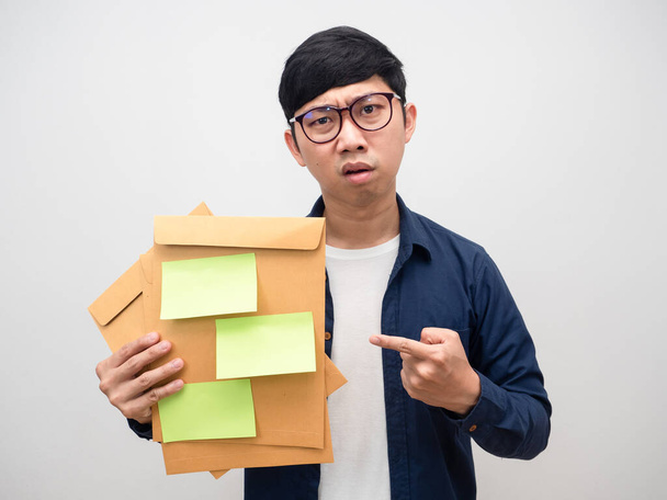 Young businessman holding envelope papers feel tried about workYoung businessman point finger at envelope papers feel tried about work - 写真・画像