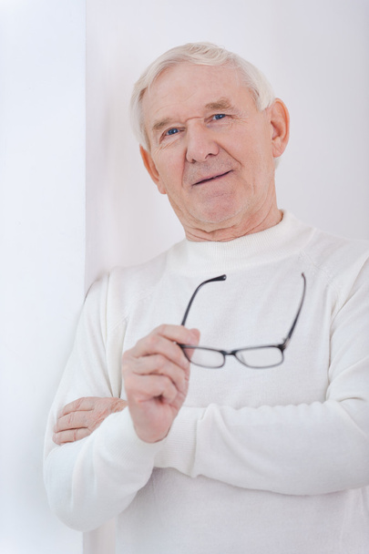 Senior homem segurando óculos
 - Foto, Imagem