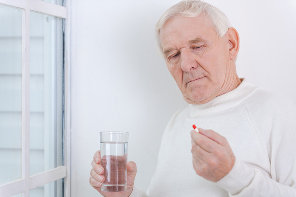 Senior man holding medicines - Foto, Imagen