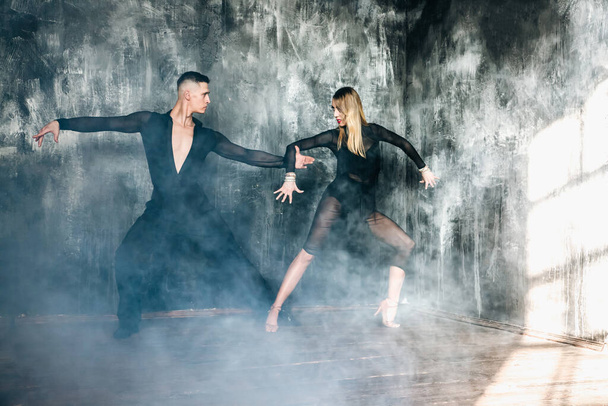 Couple of two professional ballroom dancers is dancing on loft studio. Beautiful art performance. Sport life concept. Passion and emotional dance. - Foto, Bild