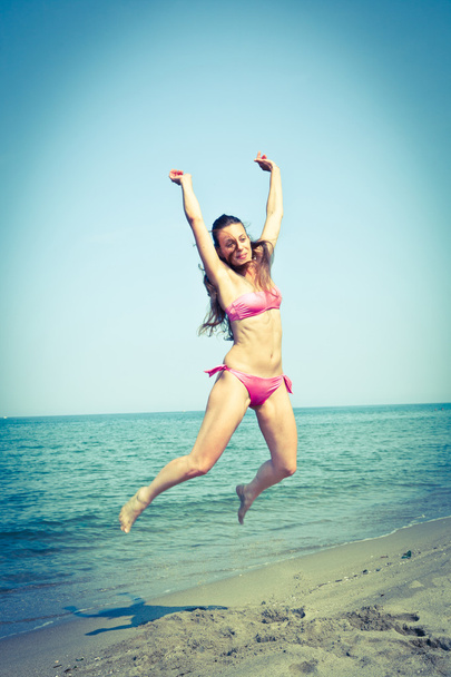 Onnellinen nainen hyppää rannalla Seaside
 - Valokuva, kuva