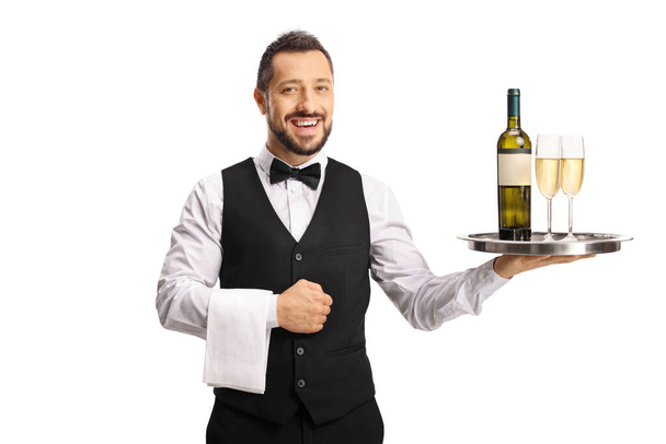 Smiling waiter holding bottle of wine and glasses on a tray isolated on white background - Foto, Bild