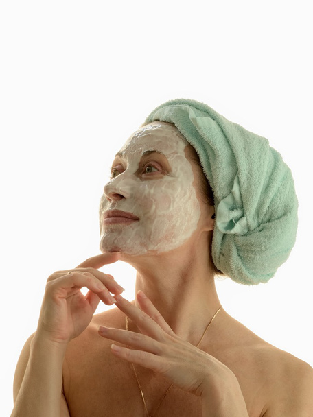 Γυναίκα με καλλυντικά μάσκα, φροντίζουν ένα δέρμα στο πρόσωπό της - Φωτογραφία, εικόνα