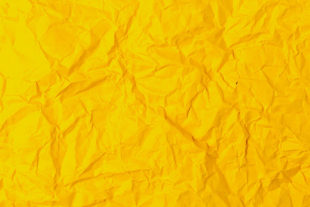 レトロな古いヴィンテージの古典的なグランジペーパーのラフなしわの質感の表面。背景や背景。設計は空白だ。純粋な黄色またはほとんど純粋な黄色 - 写真・画像