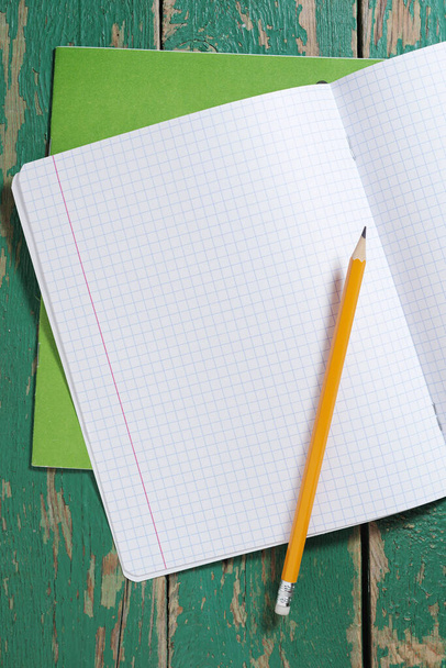 School notebook and pencil on old green wooden table, top view - Foto, imagen