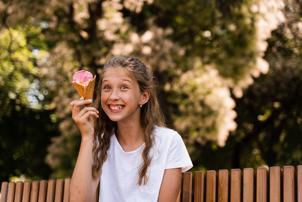 Funny child girl have fun with ice cream cone in waffle cup. Happy girl smiling, laughing and grimacing. Creative advert for ice cream stand and shop - Foto, afbeelding