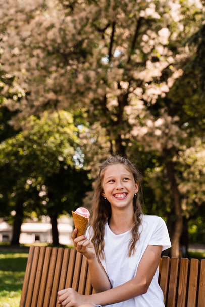 Funny child girl have fun with ice cream cone in waffle cup. Happy girl smiling, laughing and grimacing. Creative advert for ice cream stand and shop - Foto, Bild