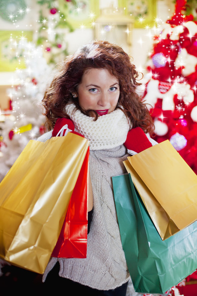 woman with curly red hair and christmas bag - Фото, зображення