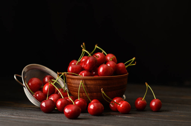 Sweet fresh cherry on a dark wooden background. - 写真・画像