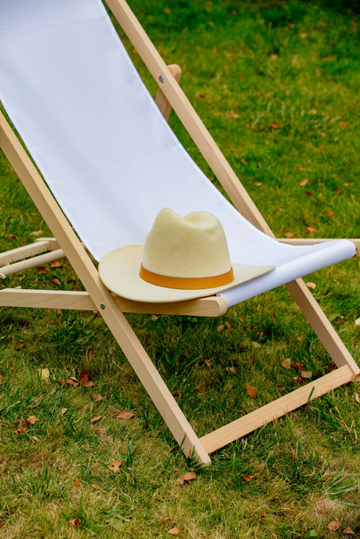 Wooden chair and hat in a garden - Фото, зображення