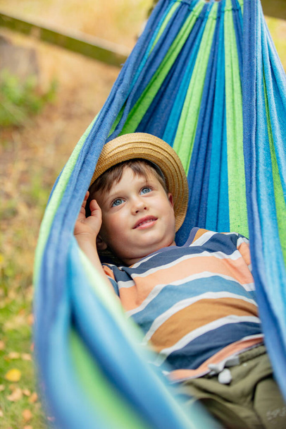 Happy kid jongen in hangmat in de zomer tuin - Foto, afbeelding