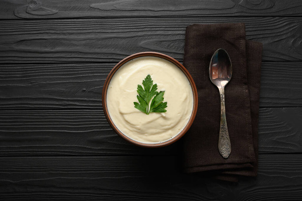 Cream of cauliflower soup on a dark wooden background. - Foto, imagen