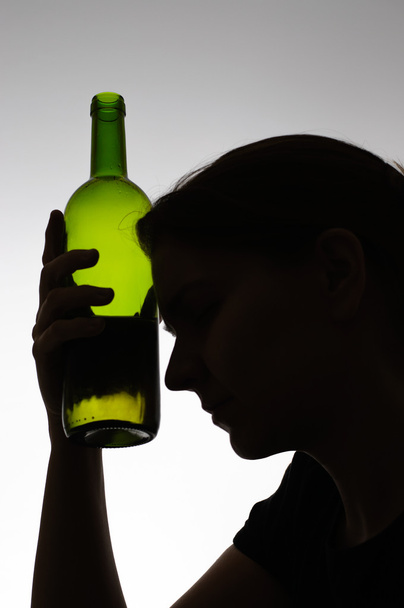 Silhouet van een vrouw met een fles - Foto, afbeelding