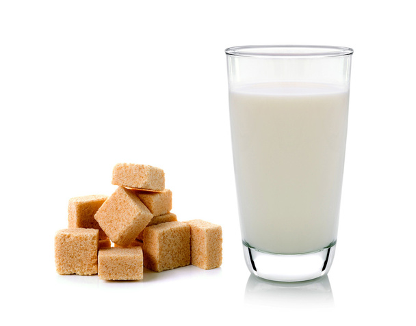 glas melk en kubussen van rietsuiker geïsoleerd op witte CHTERGRO - Foto, afbeelding