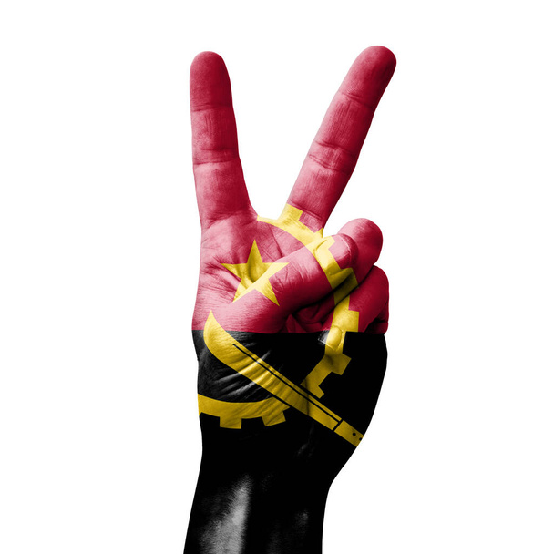 Руки роблять знак перемоги V з прапором Анголи. - Фото, зображення