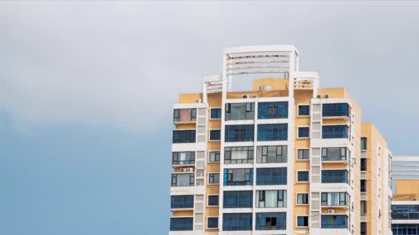 Time-lapse βίντεο ενός σύγχρονου κτιρίου κατοικιών με μπλε ουρανό και λευκά σύννεφα σε μια ηλιόλουστη μέρα - Πλάνα, βίντεο