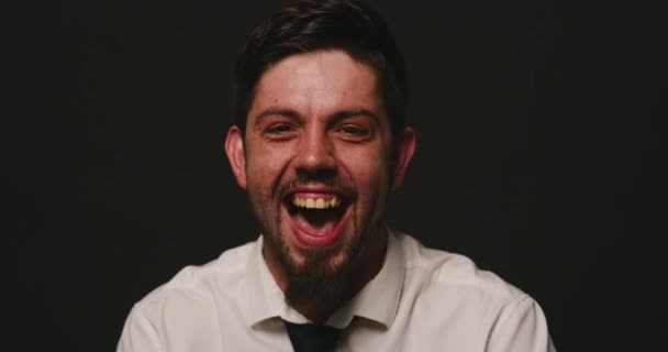 Portrait of a bipolar patient against black studio copy space background. Mentally ill man shouting and laughing showcasing multiple personalities suffering from schizophrenia personality disorder. - Filmagem, Vídeo