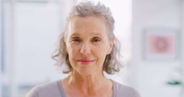 Face portrait of mature woman smiling and standing alone at home. Closeup headshot of happy senior feeling content, confident, proud and enjoying. Showing white teeth after whitening dental treatment. - Záběry, video