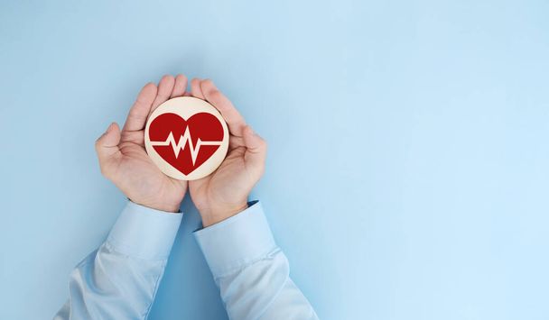 medico che tiene un cuore su uno sfondo blu. concetto di assistenza sanitaria e medica. - Foto, immagini