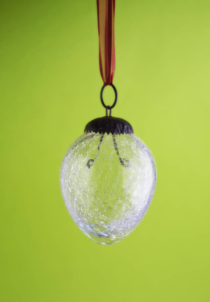 Closeup of a glass lightbulb against a green copyspace background. Zoom in on lightbulb details with no electricity to power, energy crisis, turned off for load shedding, power outage or blackout. - Photo, image