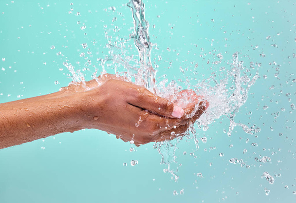 невпізнавана жінка стукає руками, щоб зловити воду на синьому фоні в студії
. - Фото, зображення