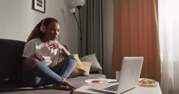 Anxious African American female watching interesting movie on laptop - Video, Çekim