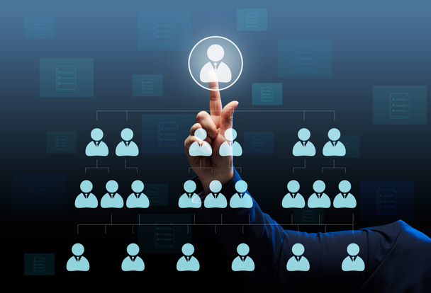 Liikemies seisoo virtuaalisen hierarkiakaavion edessä yrityksessä. Etsi lahjakkaita työntekijöitä ja henkilökunnan tukea. Liiketoiminnan alistaminen - Valokuva, kuva
