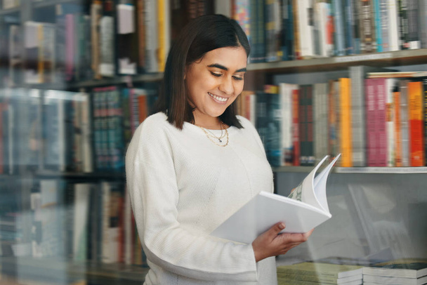 Okul kütüphanesinde kitap okuyan genç bir kız öğrenci.. - Fotoğraf, Görsel