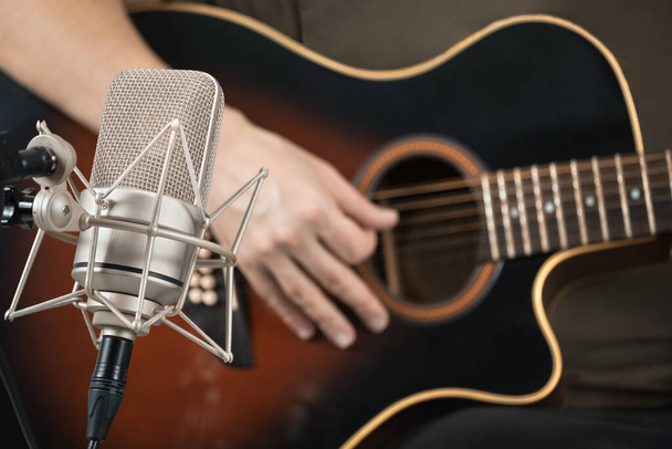 Mikrofon Aufnahme einer akustischen Gitarre gespielt von hand. Vorderansicht - Foto, Bild