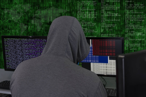 Haker siedzi za monitorami komputerowymi na abstrakcyjnym tle, atakując i hakując serwery wirusem. Tworzenie i rozpowszechnianie dezinformacji, atak DDOS. - Zdjęcie, obraz