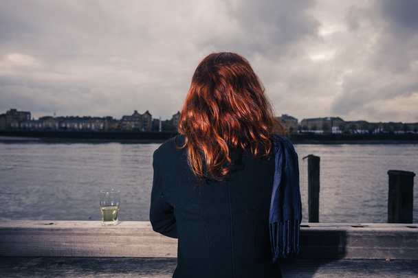 Woman drinking beer by the river - Foto, Bild