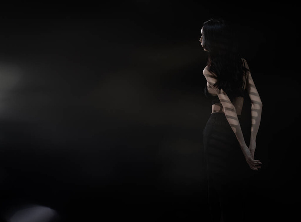 Half σώμα ασιατική όμορφη γυναίκα φορούν μαύρα lingeries με σέξι σχήμα και μακριά μαλλιά, γυρίστε πίσω όψη, αισθησιακό θηλυκό κάνει μόδα θέτει πάνω από σκούρο φόντο καπνού απομονωμένη, χαμηλής έκθεσης αντίγραφο χώρο - Φωτογραφία, εικόνα