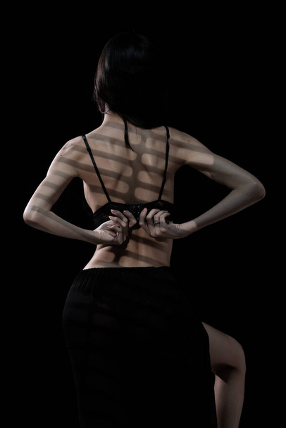 Half body Asian beautiful woman wear black lingeries with sexy shape and long hair, turn back rear view, sensual female do fashion poses over dark smoke background isolated, low exposure copy space - Foto, Imagen