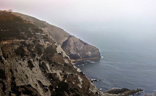 Θαλάσσιο τοπίο με απόκρημνη ακτή με ομίχλη στη θάλασσα - Φωτογραφία, εικόνα