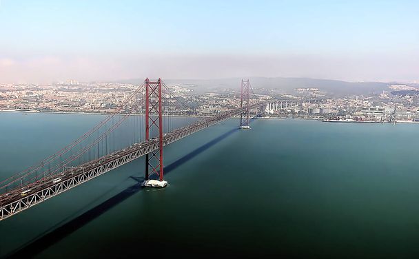 Αεροφωτογραφία πάνω από γέφυρα με μια πόλη στο βάθος - Φωτογραφία, εικόνα