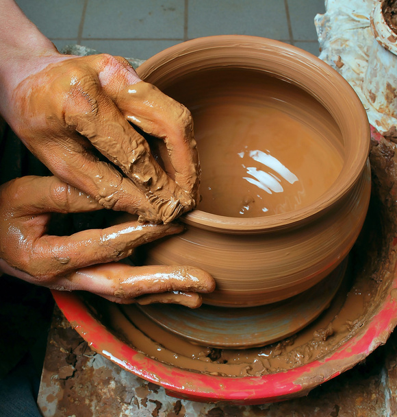 Руки гончара, создающего глиняную банку на круге - Фото, изображение