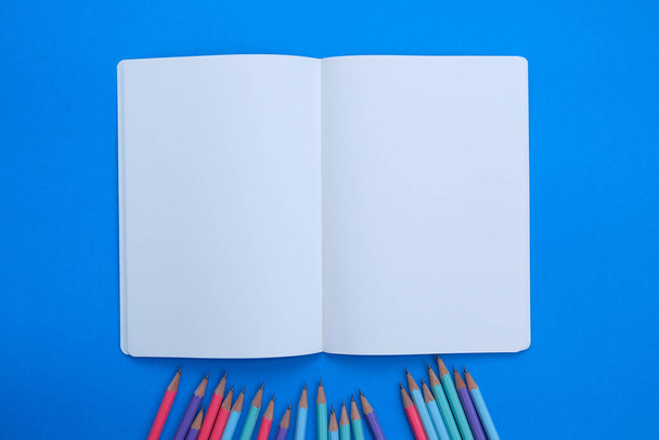 карандаши и ноутбук на цветном фоне  - Фото, изображение
