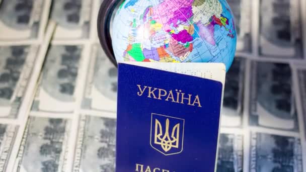 Ukrainischer Pass auf Banknoten in der Nähe des Globus. Ausreise von Flüchtlingen aufgrund des Krieges in der Ukraine - Filmmaterial, Video