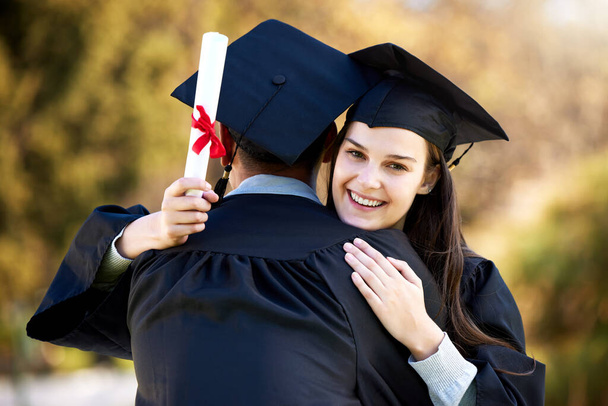Portrait of a young woman hugging her friend on graduation day. - Photo, image