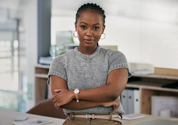 a young businesswoman standing with her arms crossed in an office. - Fotó, kép