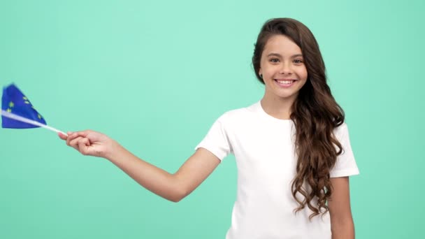 portrait of happy teen girl waving european union flag on blue background, travel. - Záběry, video
