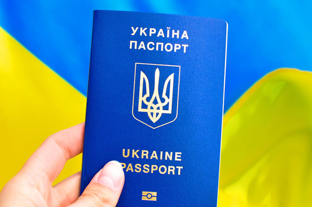 Ukrainan sisäinen Ukrainan kansainvälinen biometrinen passi ja laukku matkustaa lähistöllä. Käännös ukraina: "Ukraina, passi". - Valokuva, kuva