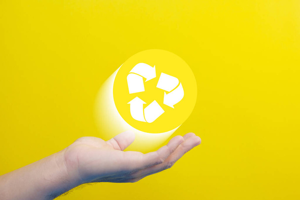 main tenant un panneau de recyclage avec un symbole de recyclage - Photo, image