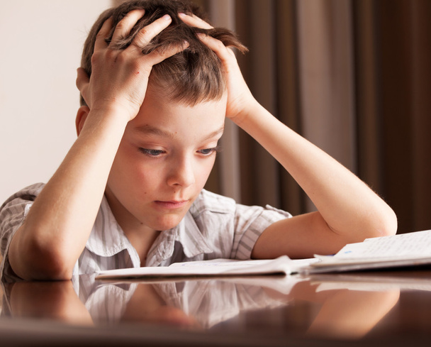 Сумний хлопчик робить домашнє завдання
 - Фото, зображення